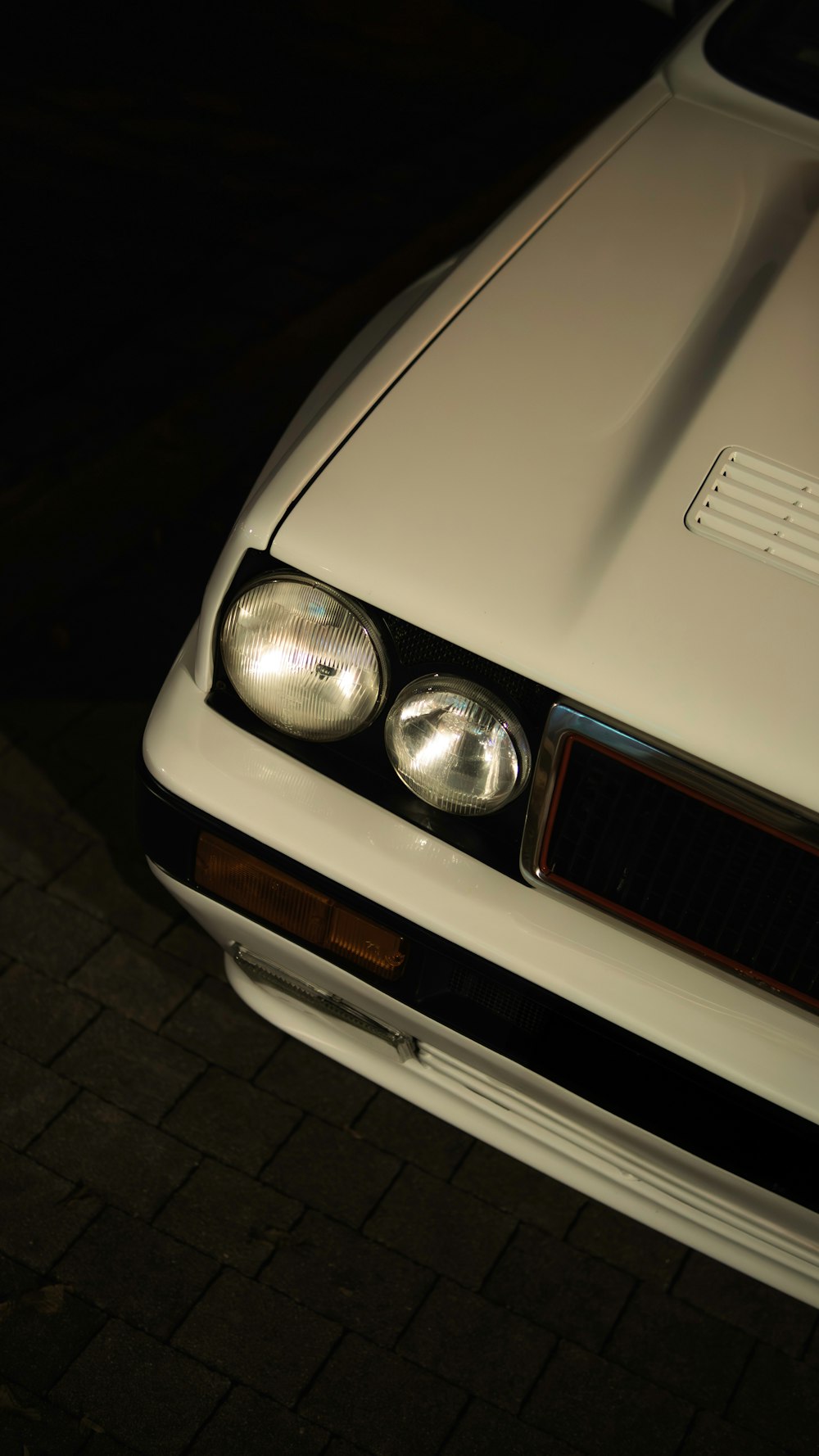 a close up of the headlights of a white car