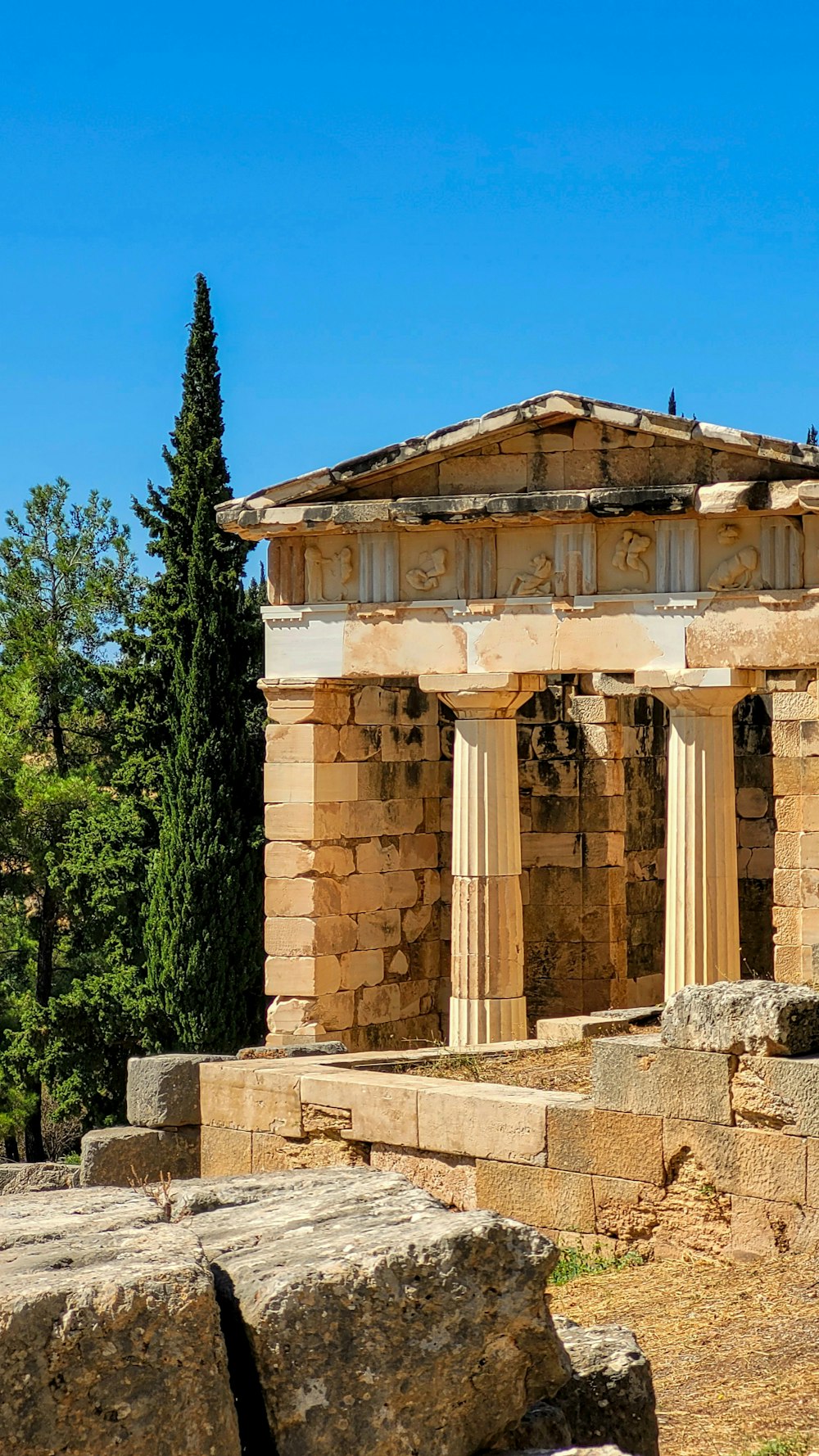 a stone structure with columns and a clock on top of it