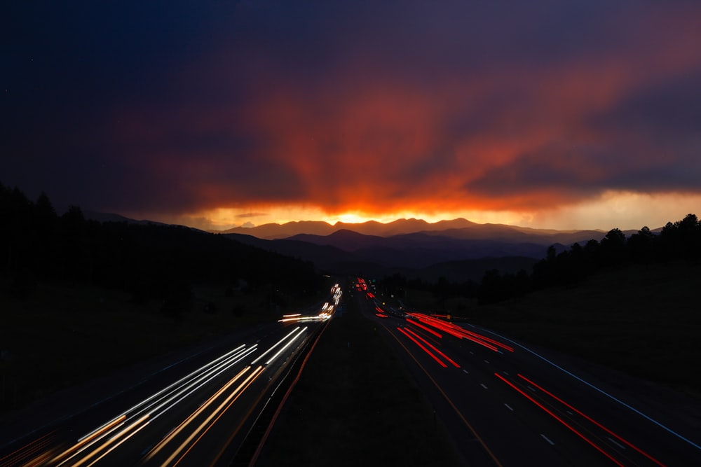 uma foto de longa exposição de um pôr do sol sobre uma rodovia