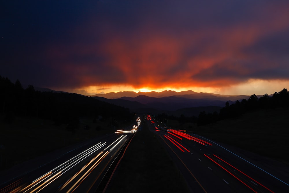 a long exposure photo of a sunset over a highway