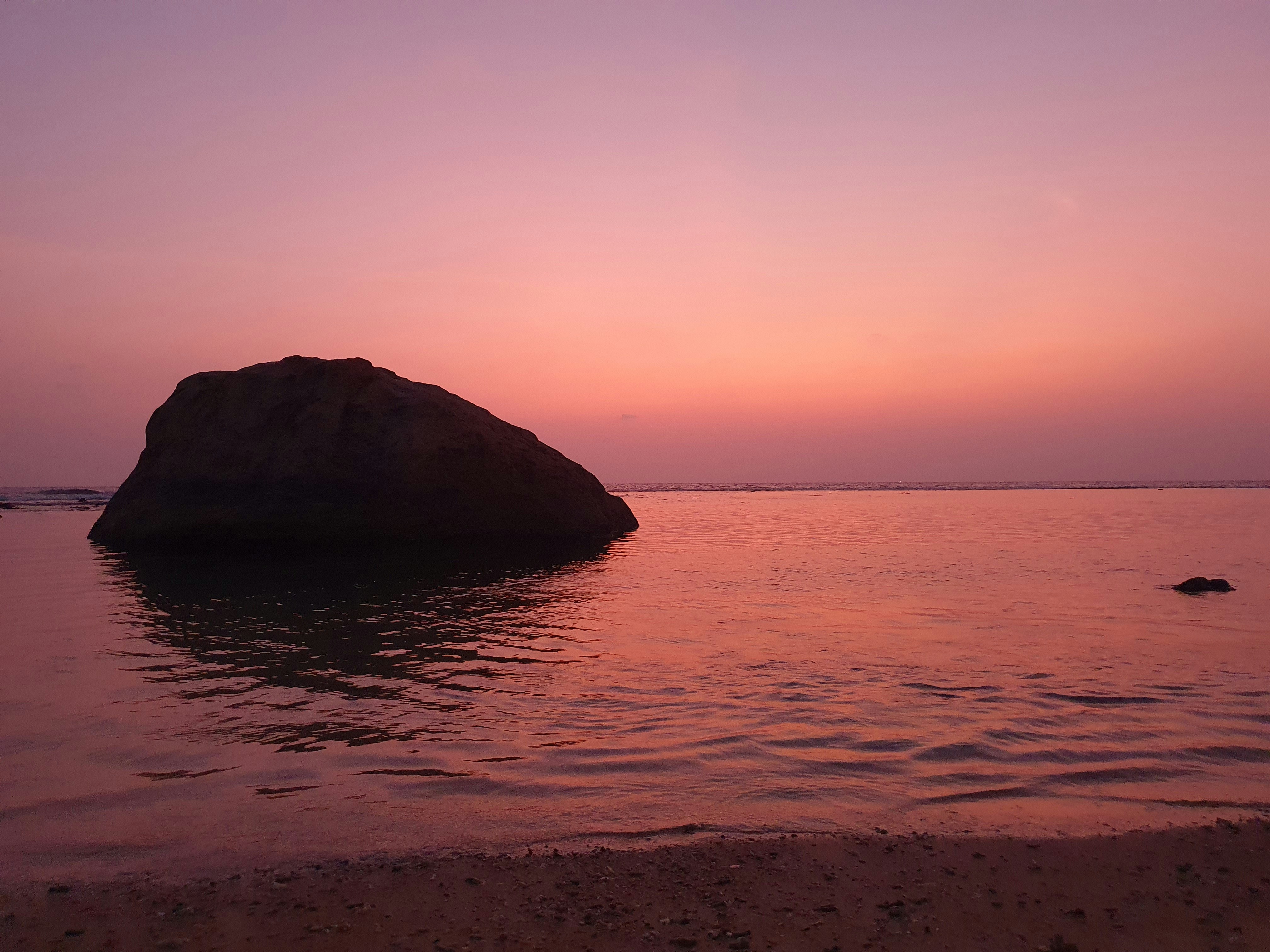 a large rock in the middle of a body of water