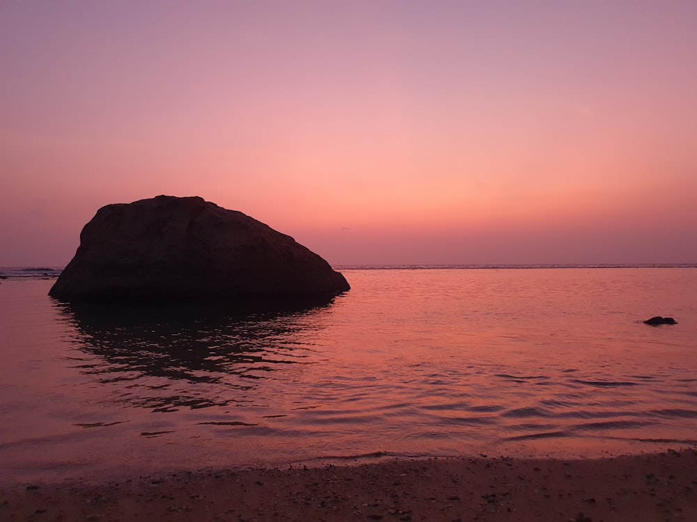 a large rock in the middle of a body of water