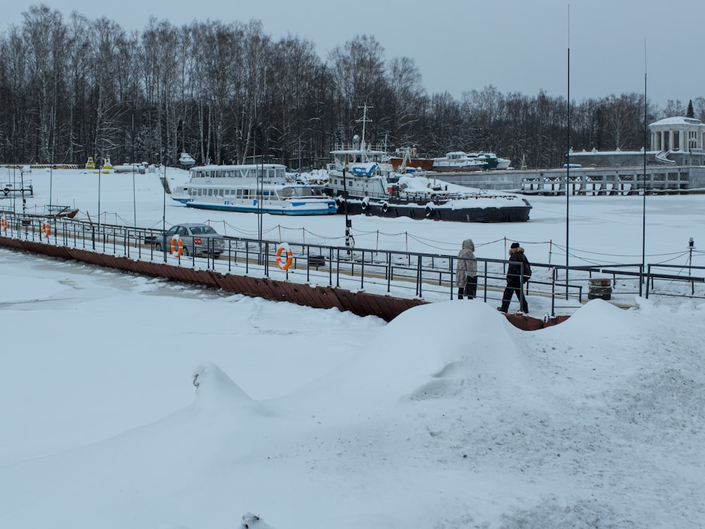 a man walking across a snow covered bridge