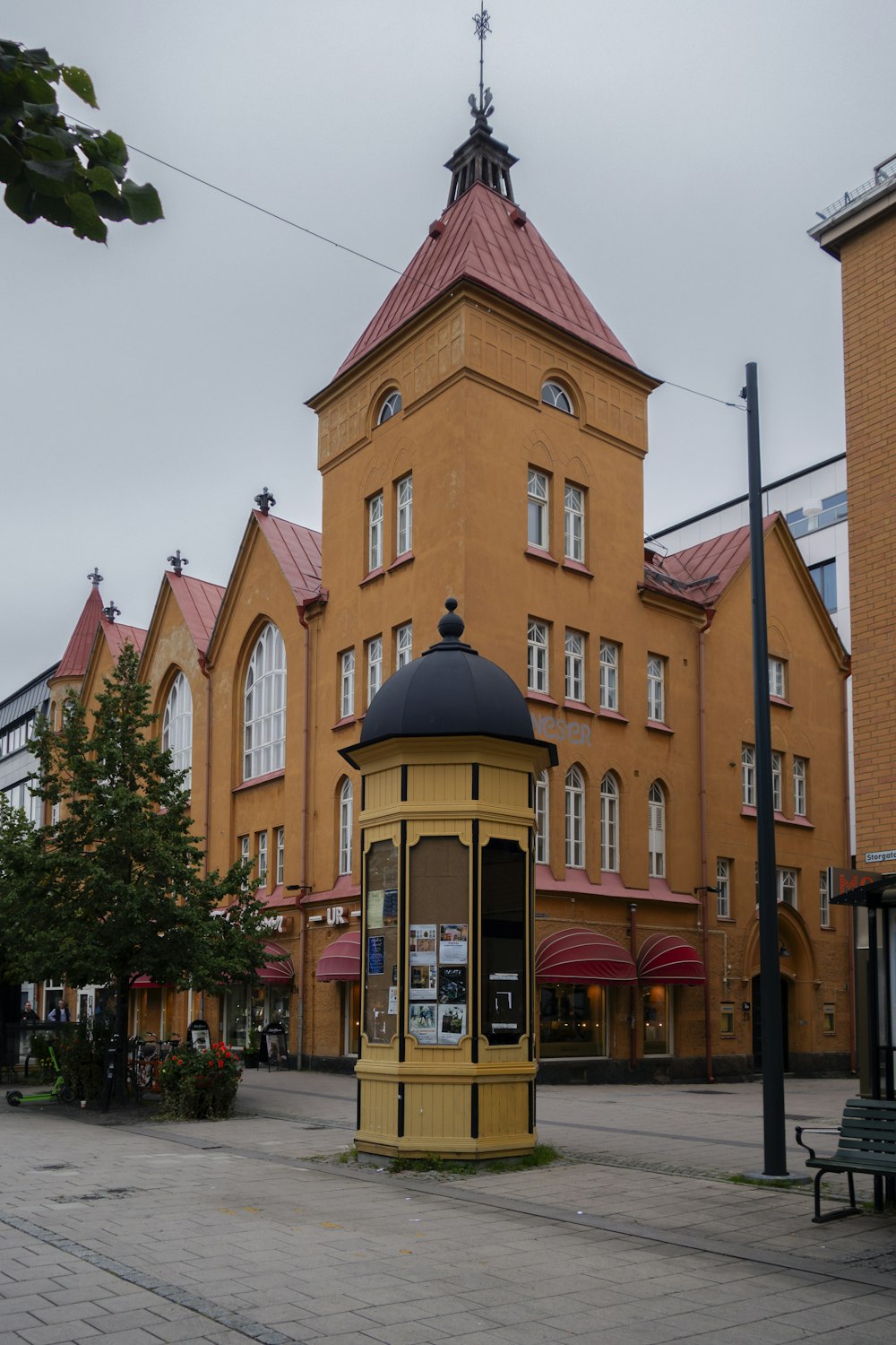 un edificio giallo con una torre dell'orologio di fronte