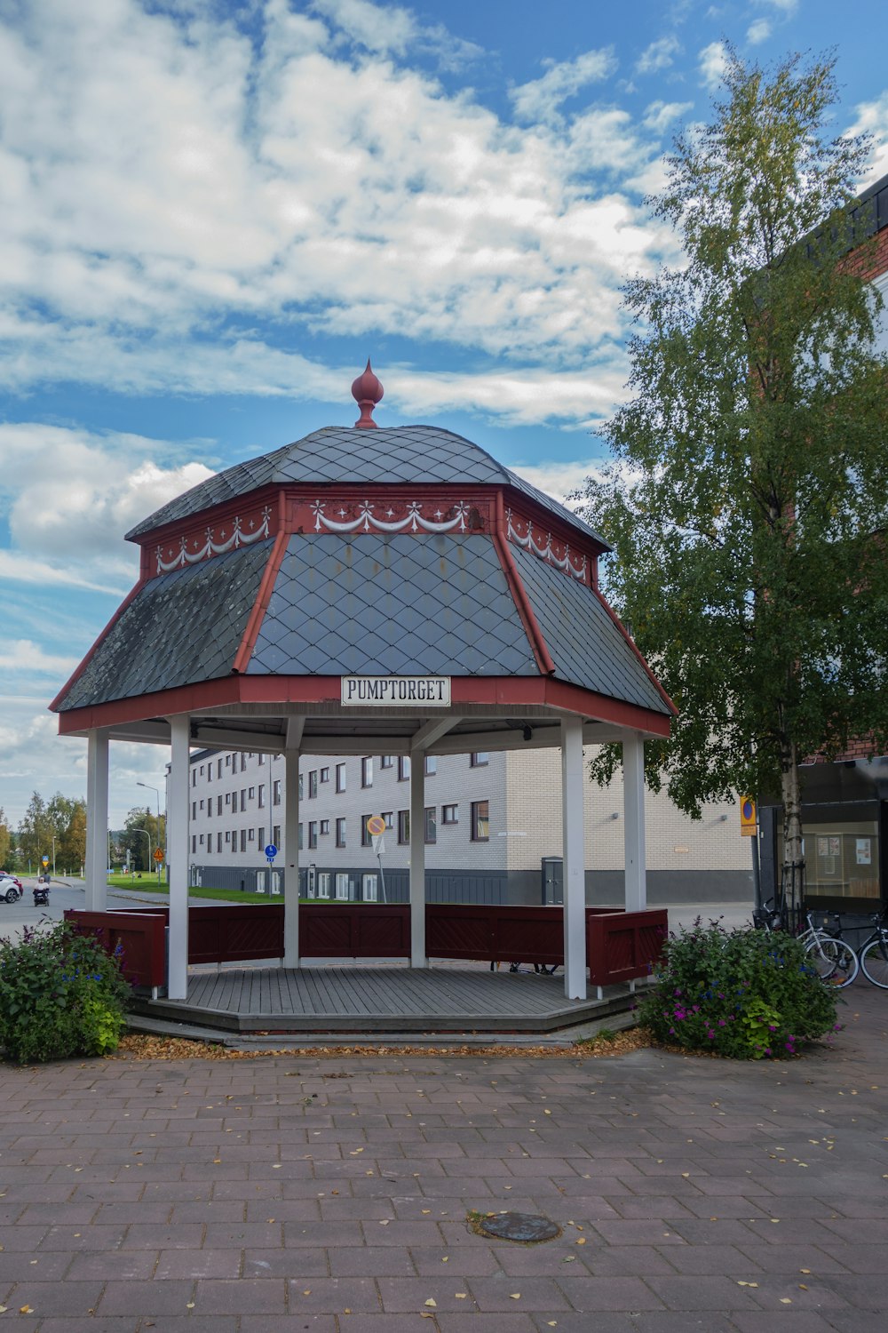 a red and white gazebo sitting on top of a sidewalk