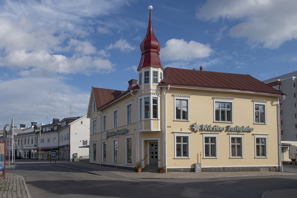 a yellow building with a red steeple on top of it