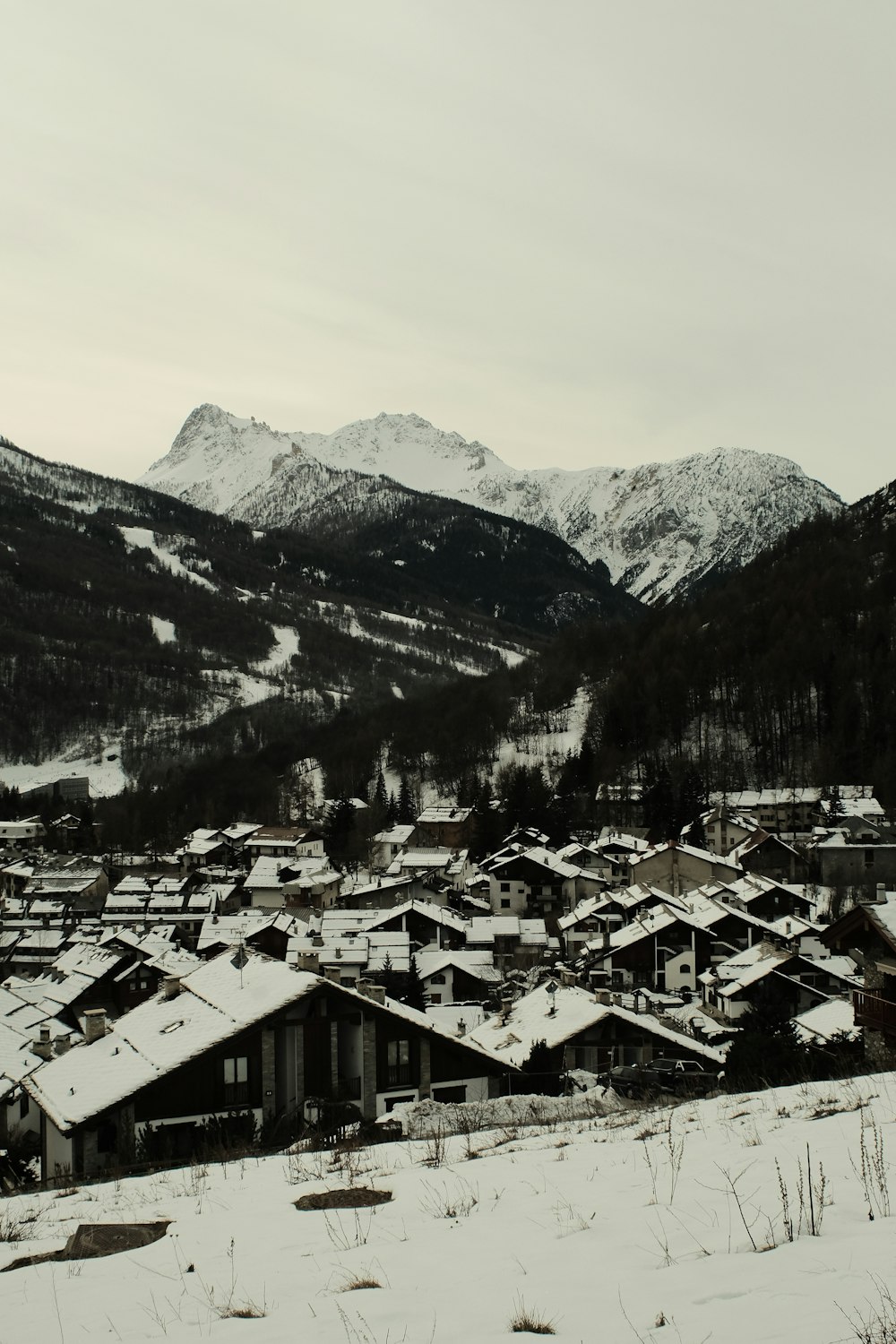 a snowy village with mountains in the background