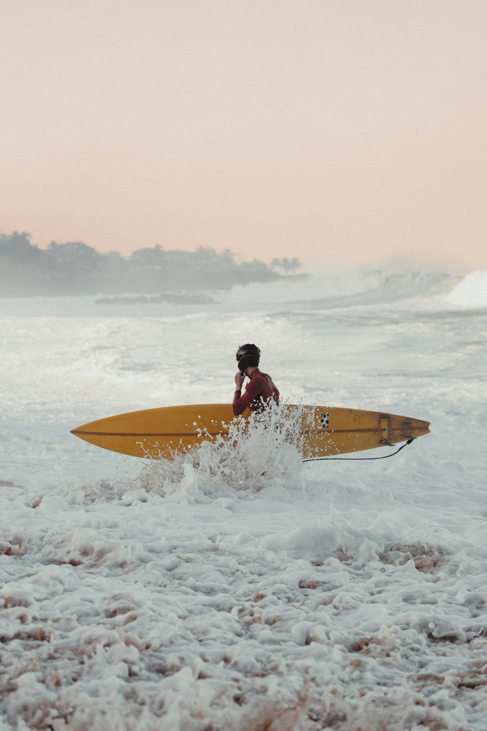 Ein Mann sitzt auf einem Surfbrett im Meer