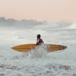 a man sitting on top of a surfboard in the ocean