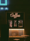 a coffee shop with a neon sign above it