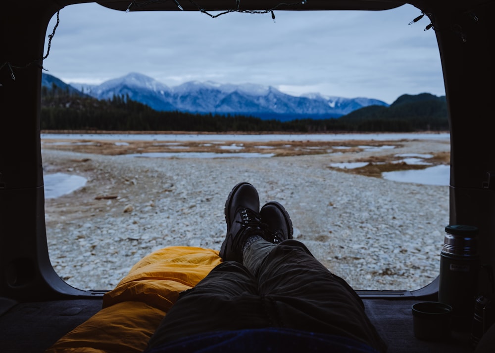 a person's feet sticking out of the window of a vehicle