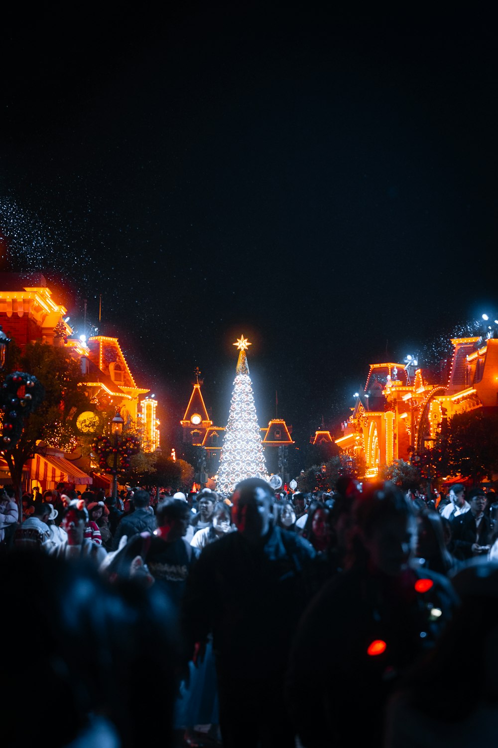 a crowd of people standing around a christmas tree