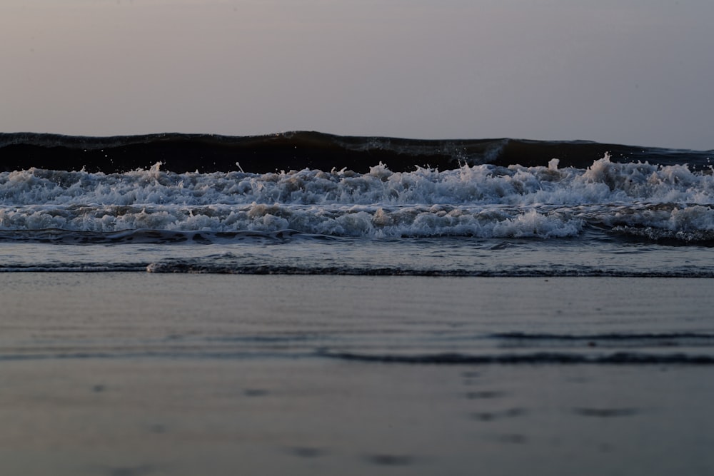 a person walking on the beach with a surfboard