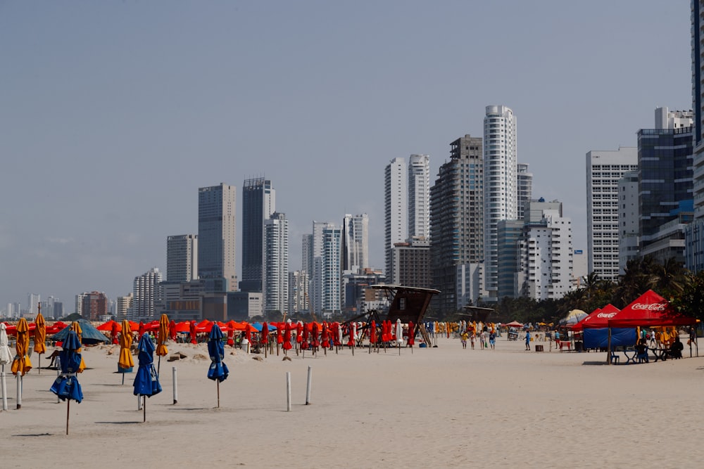 a beach with a lot of umbrellas and buildings in the background