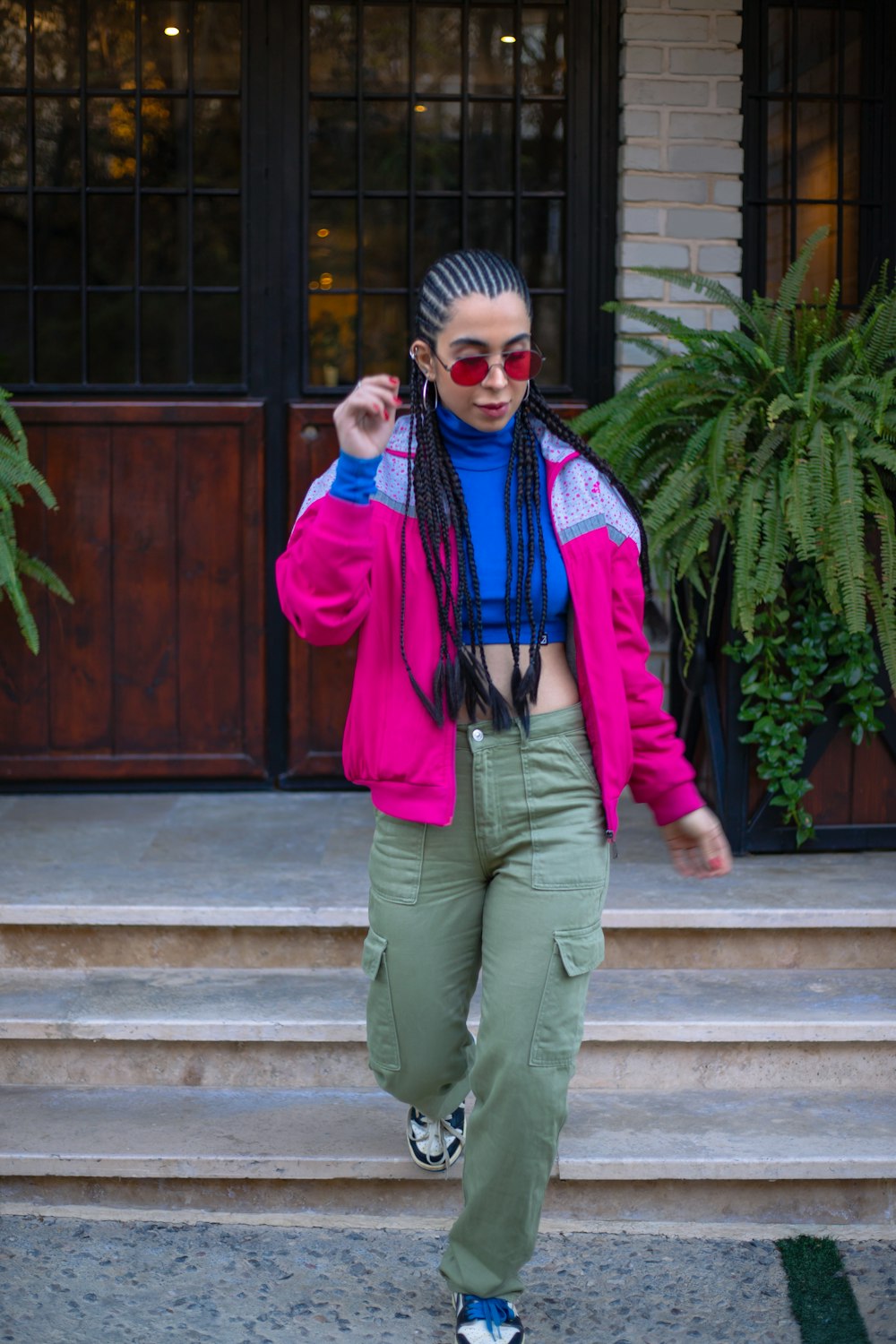 a woman in a pink jacket and green pants