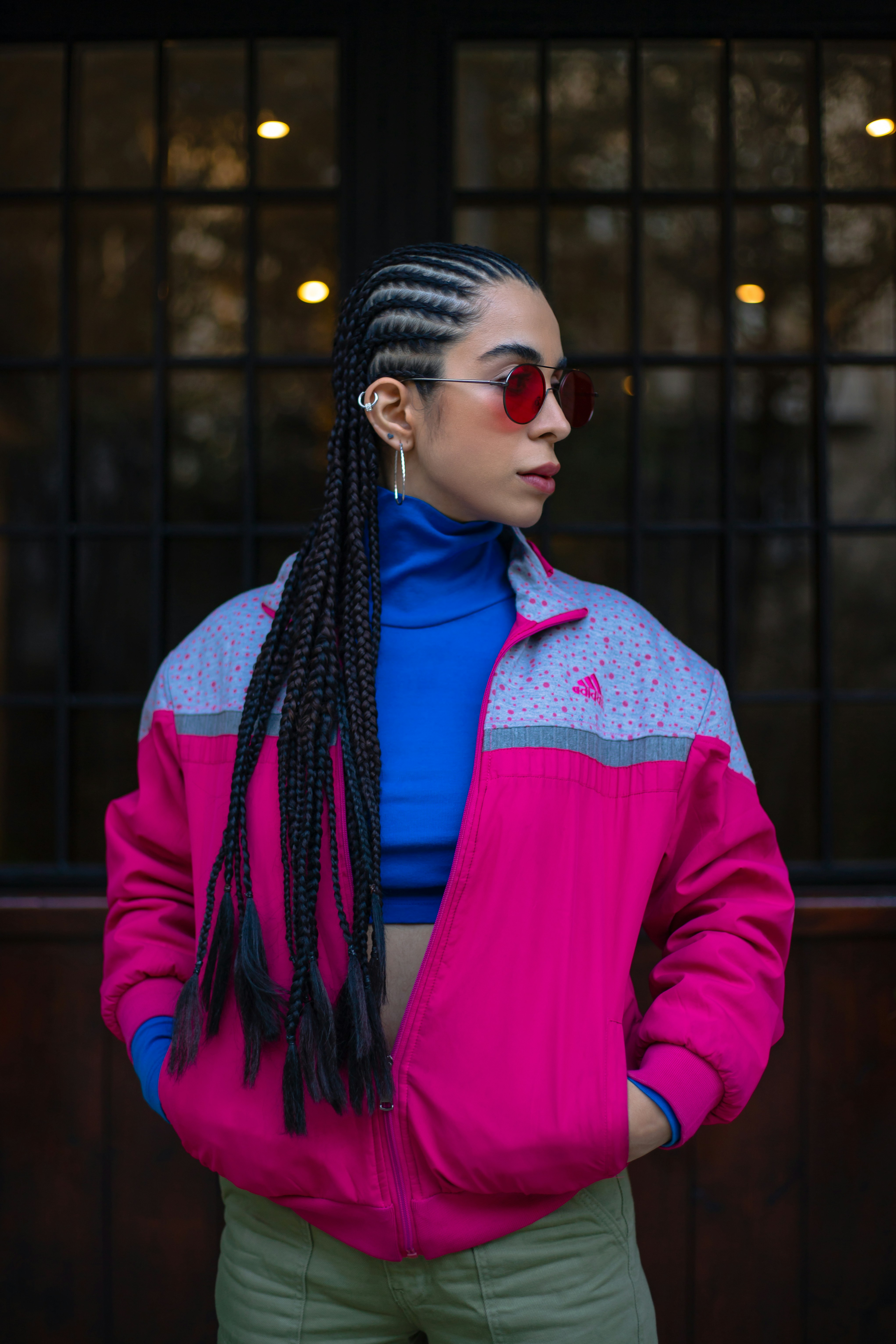 uma mulher vestindo uma jaqueta rosa e calças verdes