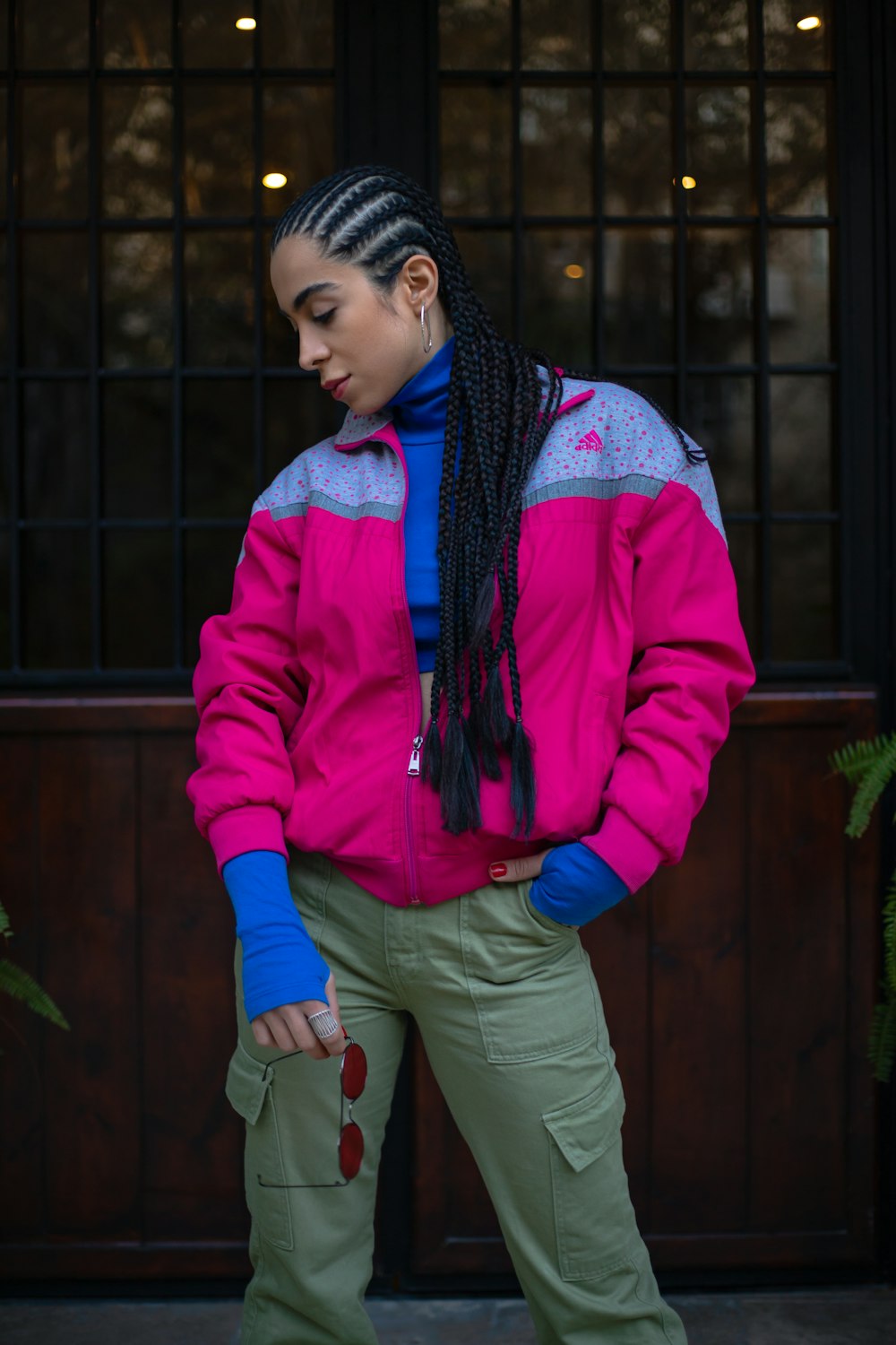 a woman in a pink jacket and green pants