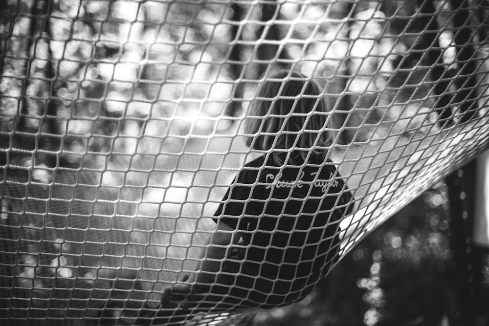 a black and white photo of a bird in a net