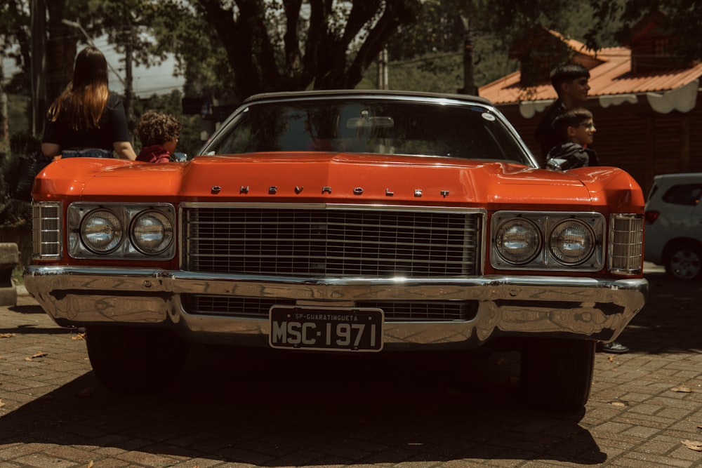 an orange car parked on the side of the road