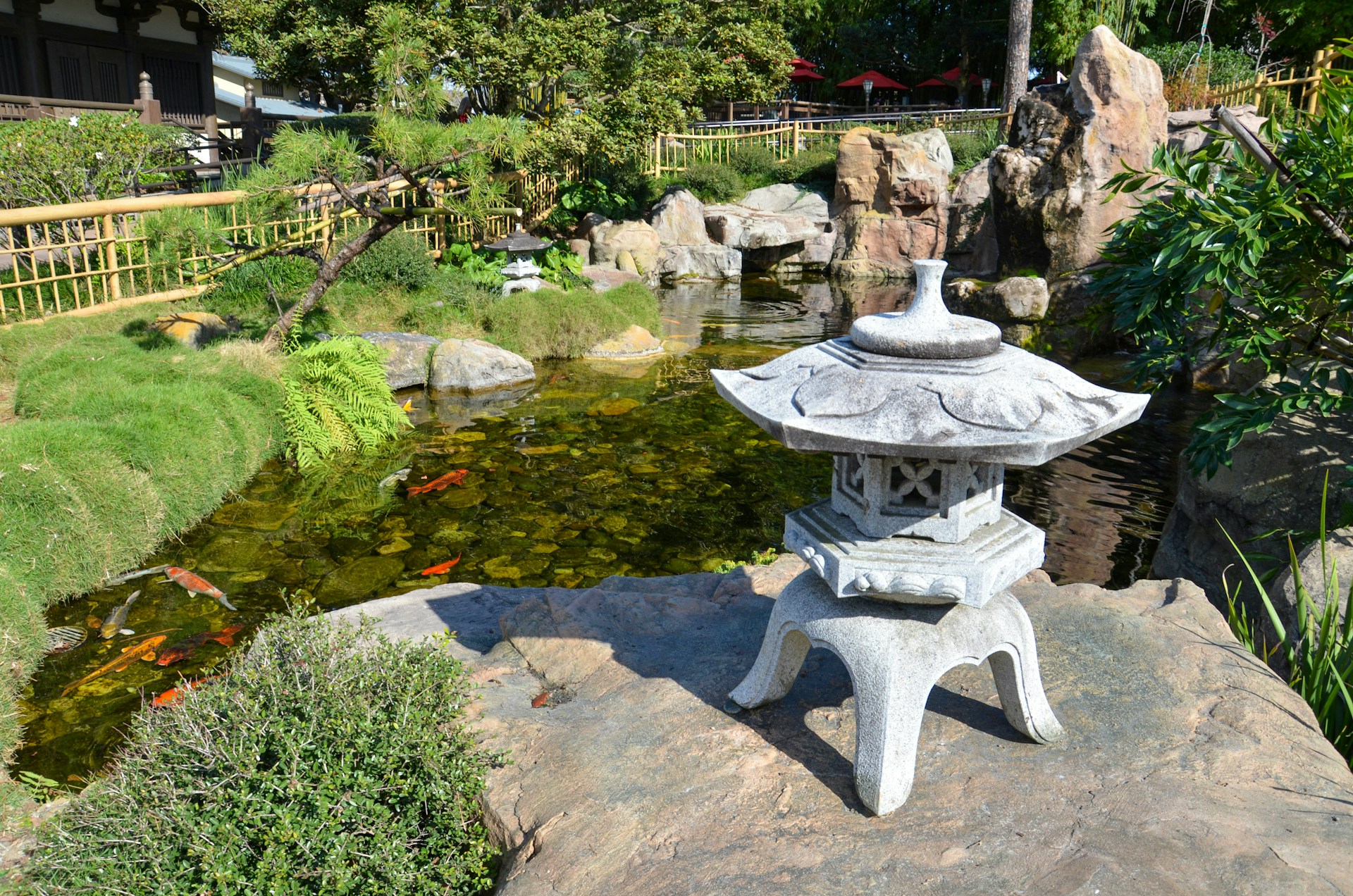 a stone lantern sitting on top of a rock next to a pond