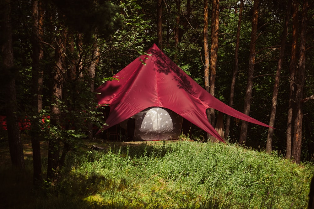 a red tent in the middle of a forest