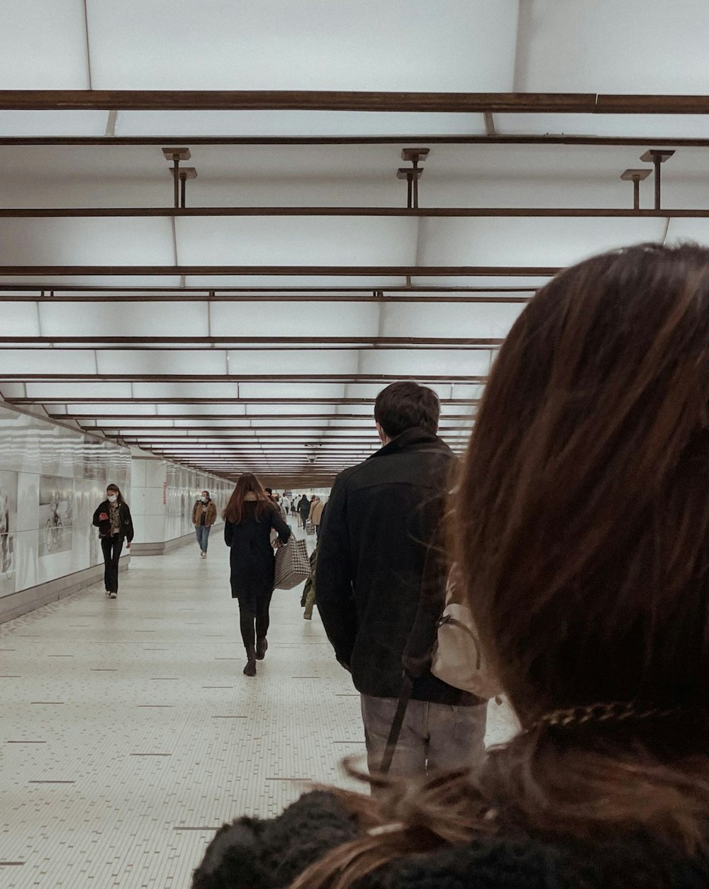 a group of people walking through a subway station