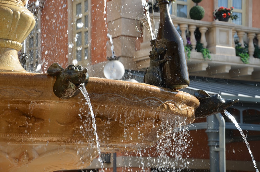 a close up of a water fountain with a building in the background