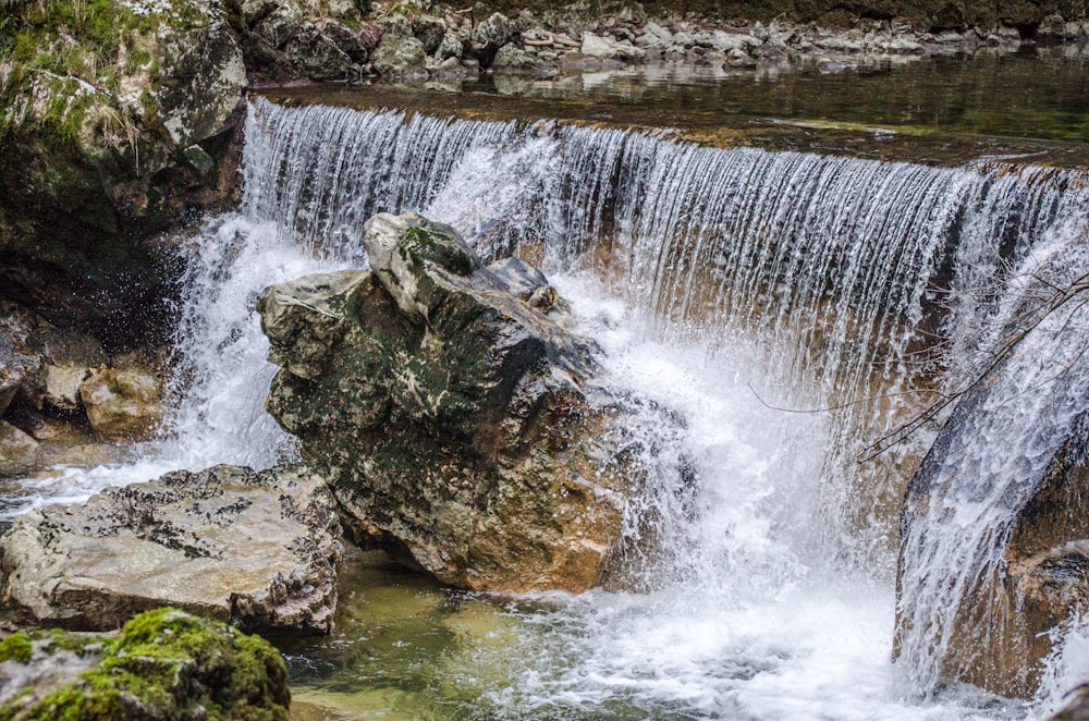 une petite cascade avec beaucoup d’eau qui en sort