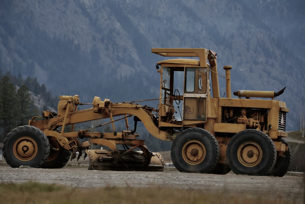a large yellow bulldozer sitting on top of a gravel road