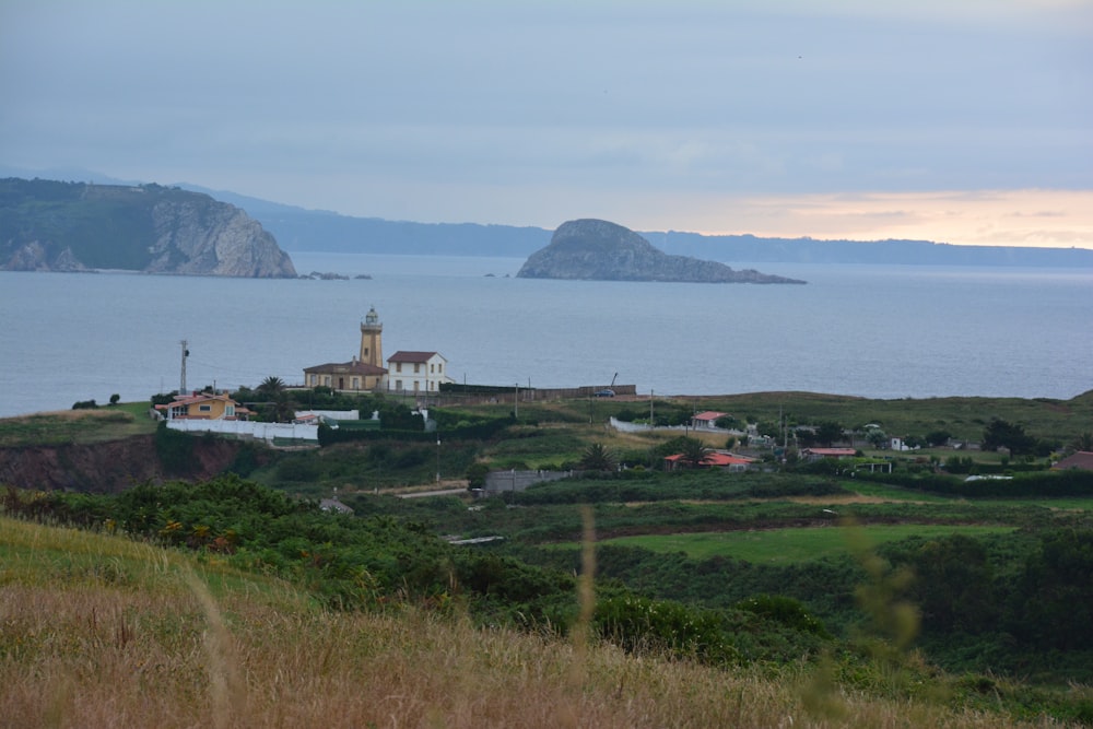 a lighthouse on a hill overlooking a body of water