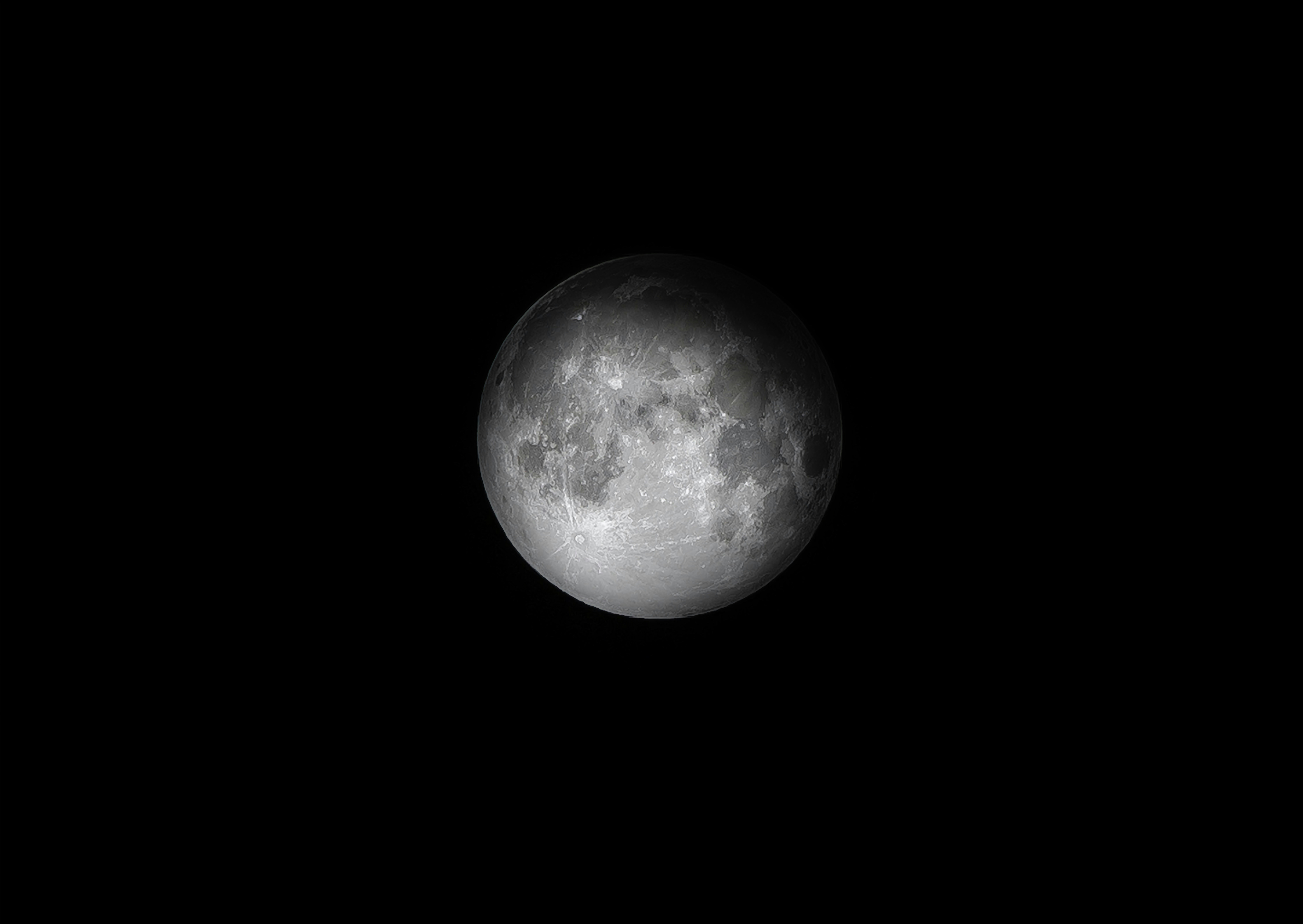 a full moon in the dark sky with a black background
