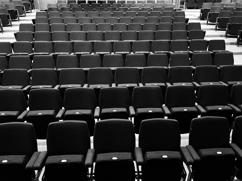 rows of black chairs in a large room