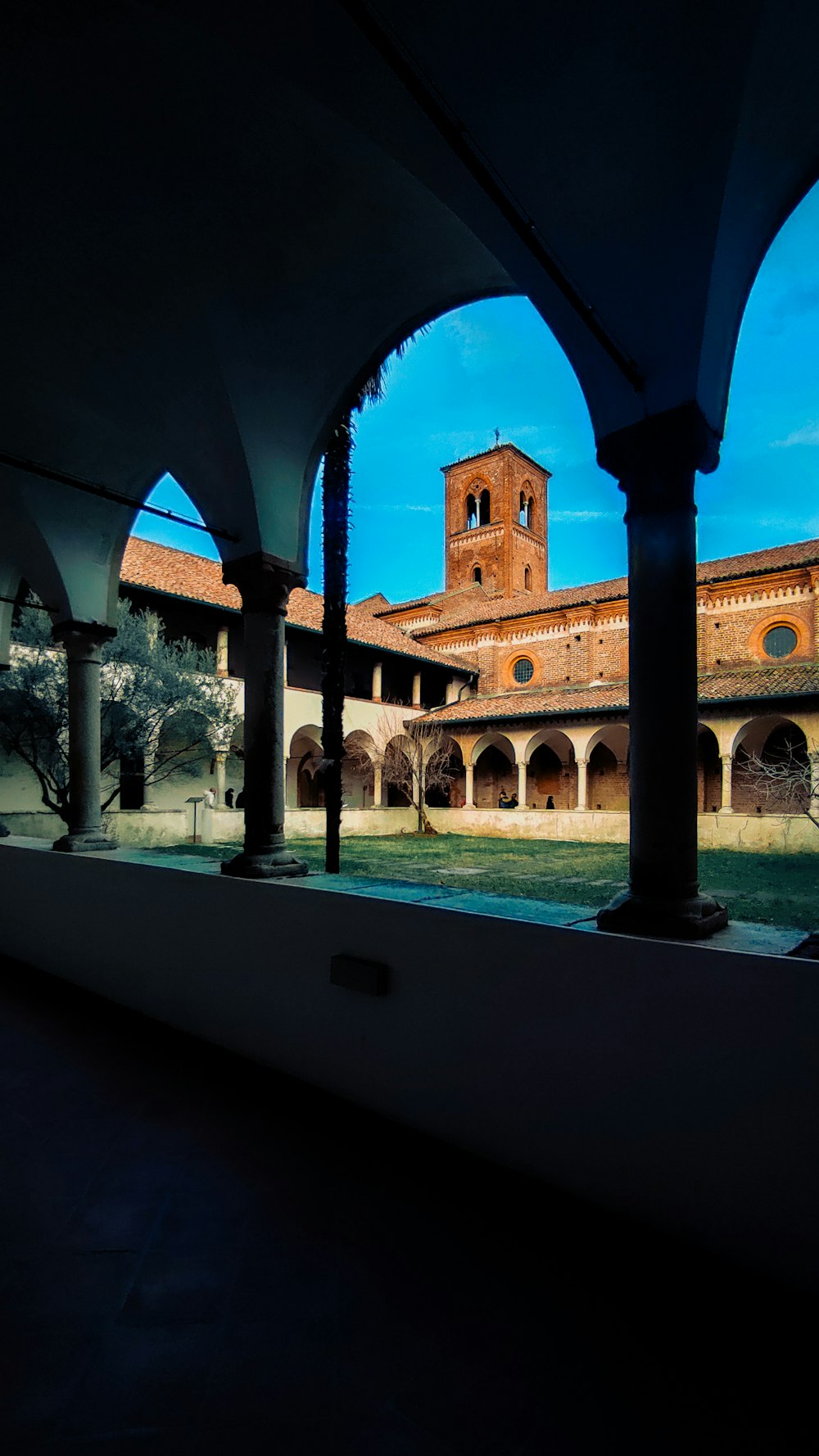 a building with arches and a clock tower in the background