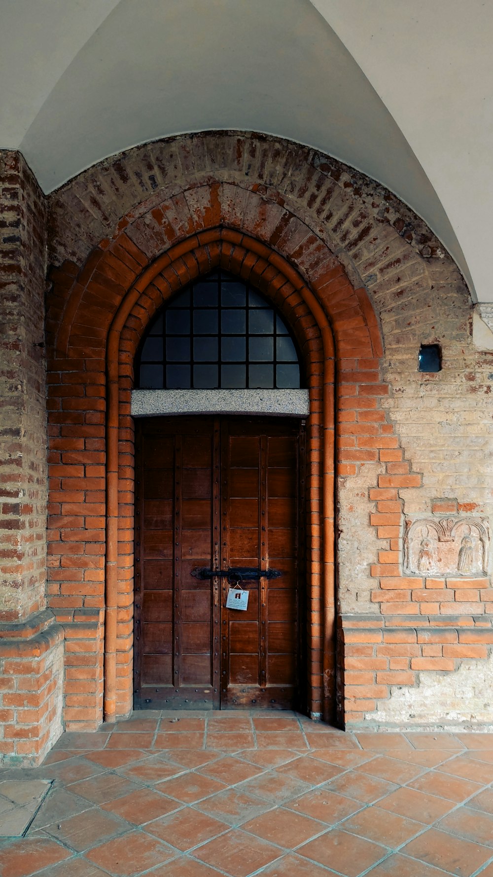 an arched doorway with a cross on the door