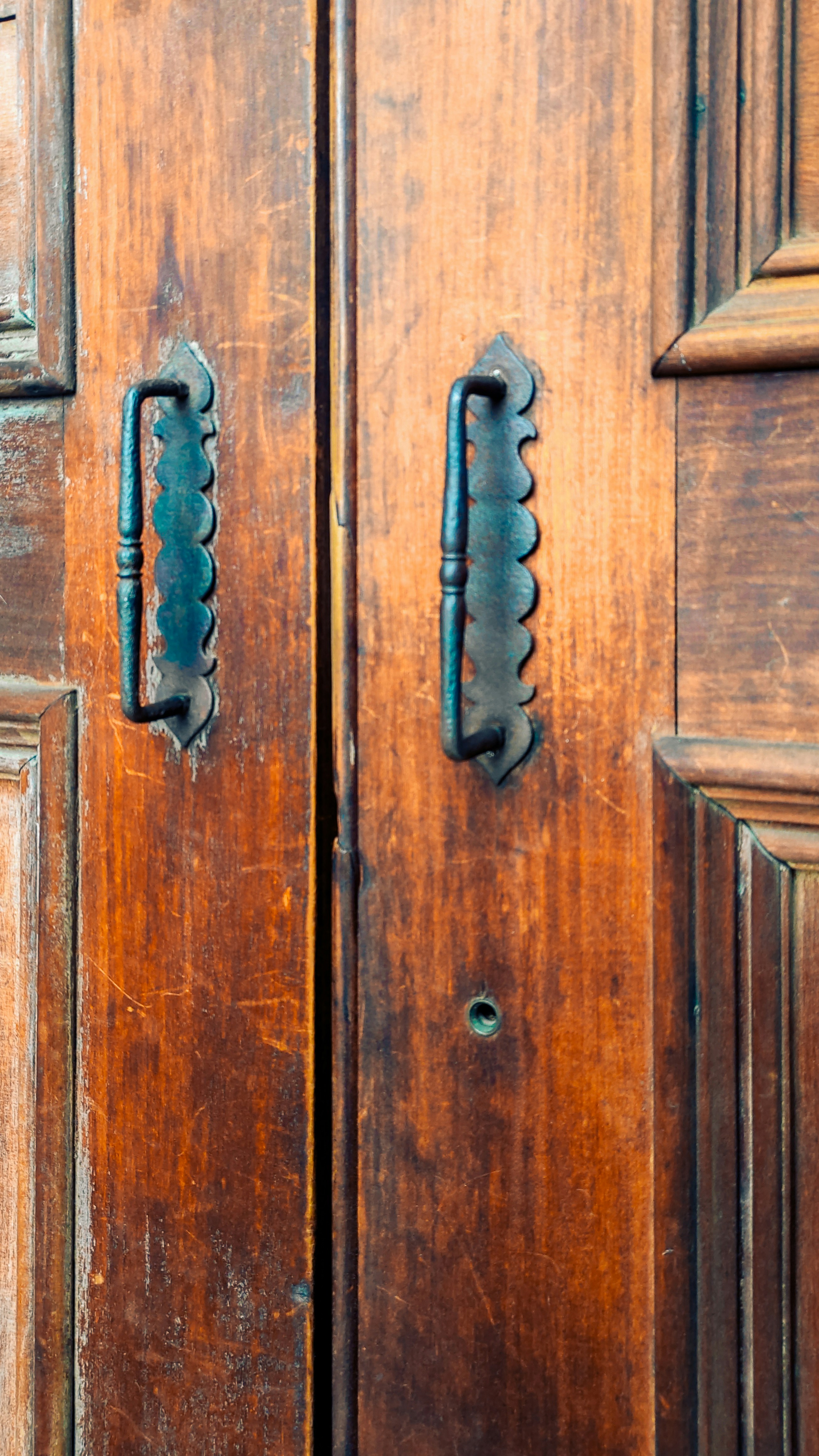 a close up of a wooden door with metal handles
