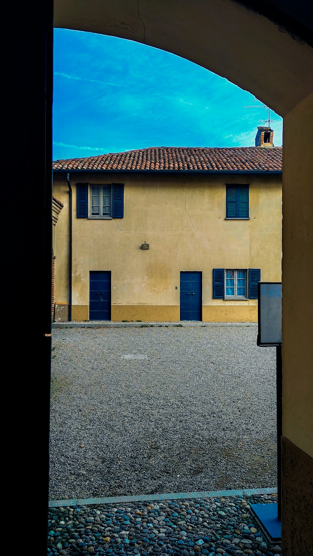 a yellow building with a blue door and windows