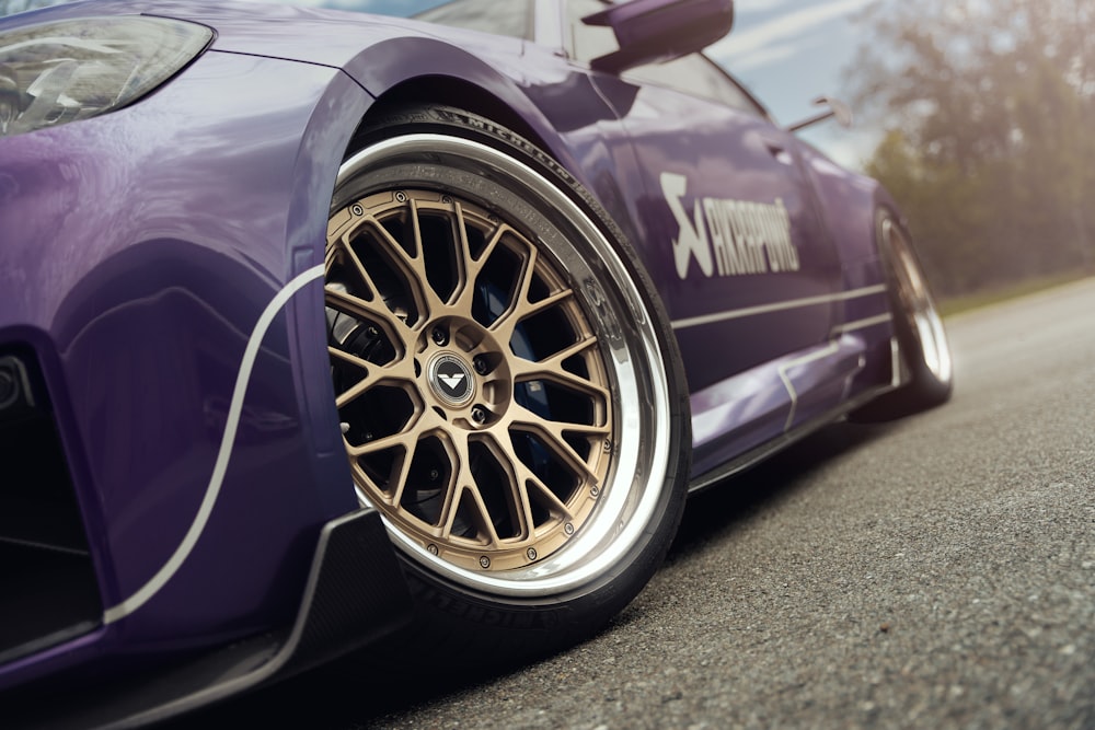 a purple sports car parked on the side of the road