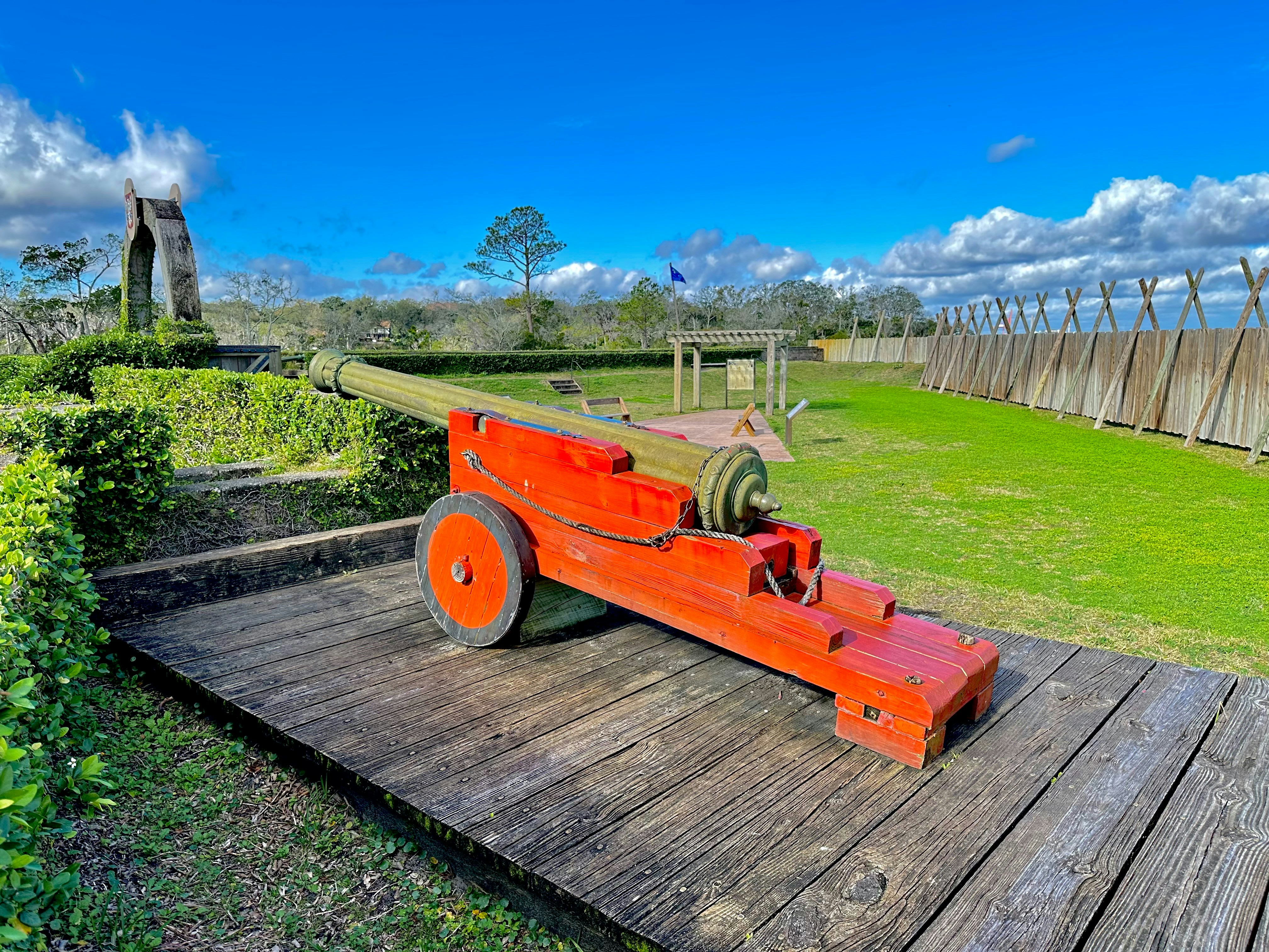 a cannon on a wooden platform in a grassy area
