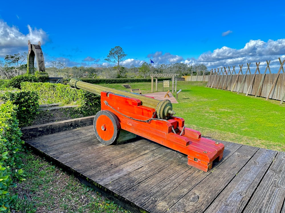 un canon sur une plate-forme en bois dans une zone herbeuse