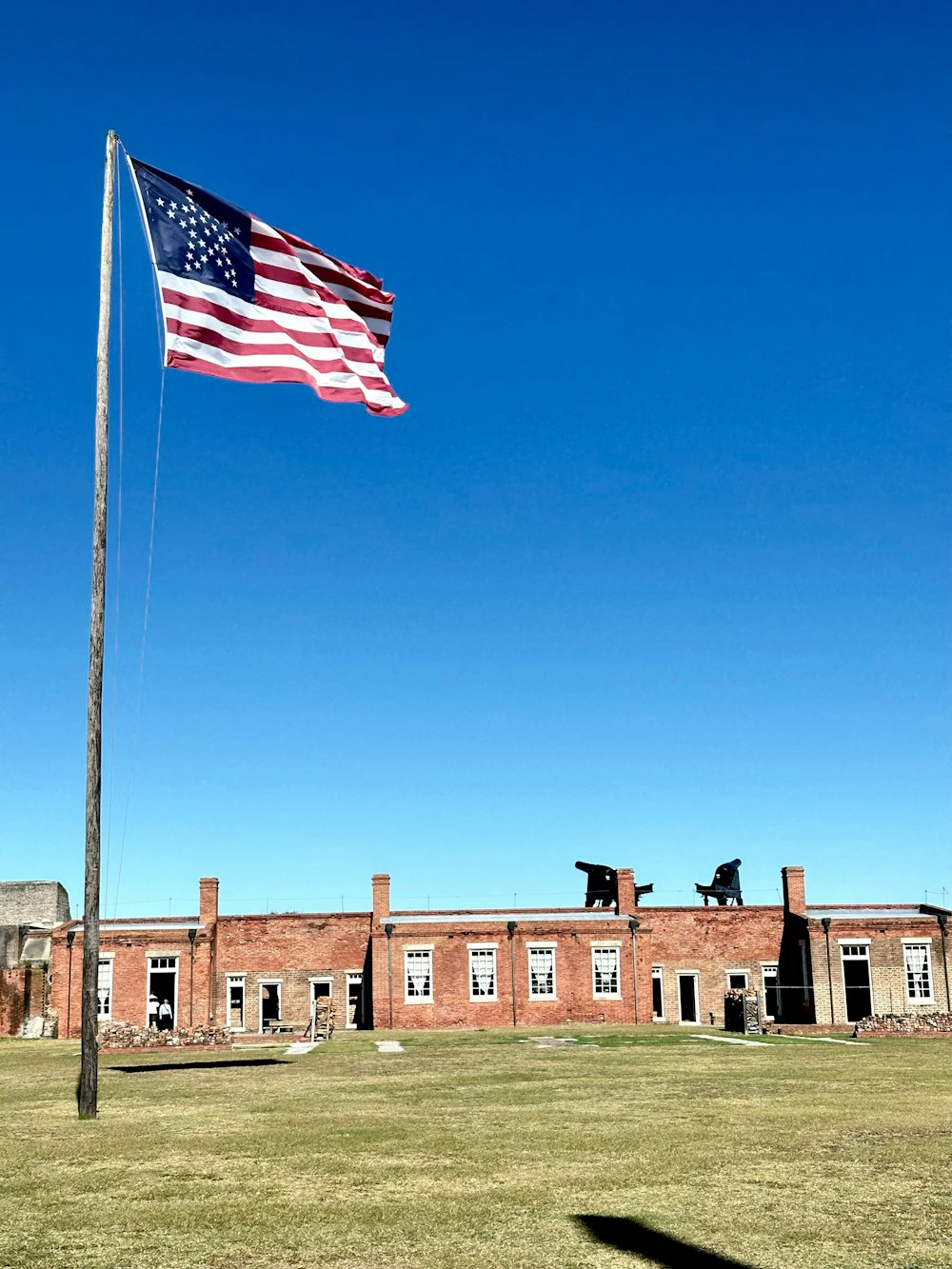an american flag flying in front of a brick building