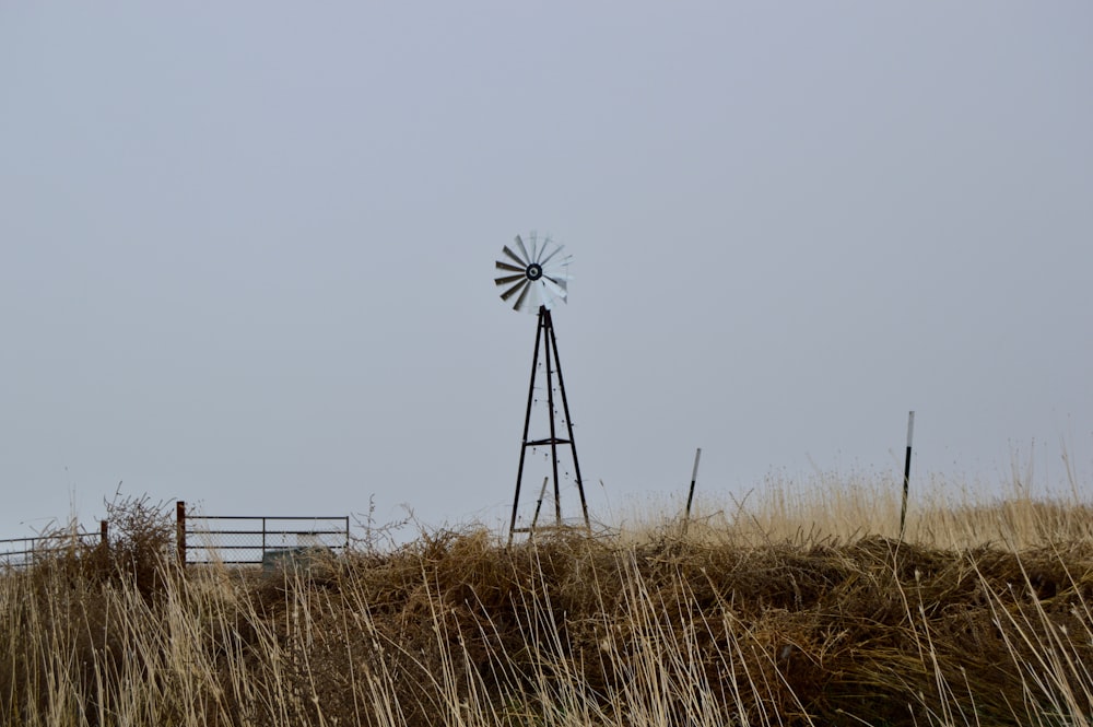 a windmill on top of a hill in a field