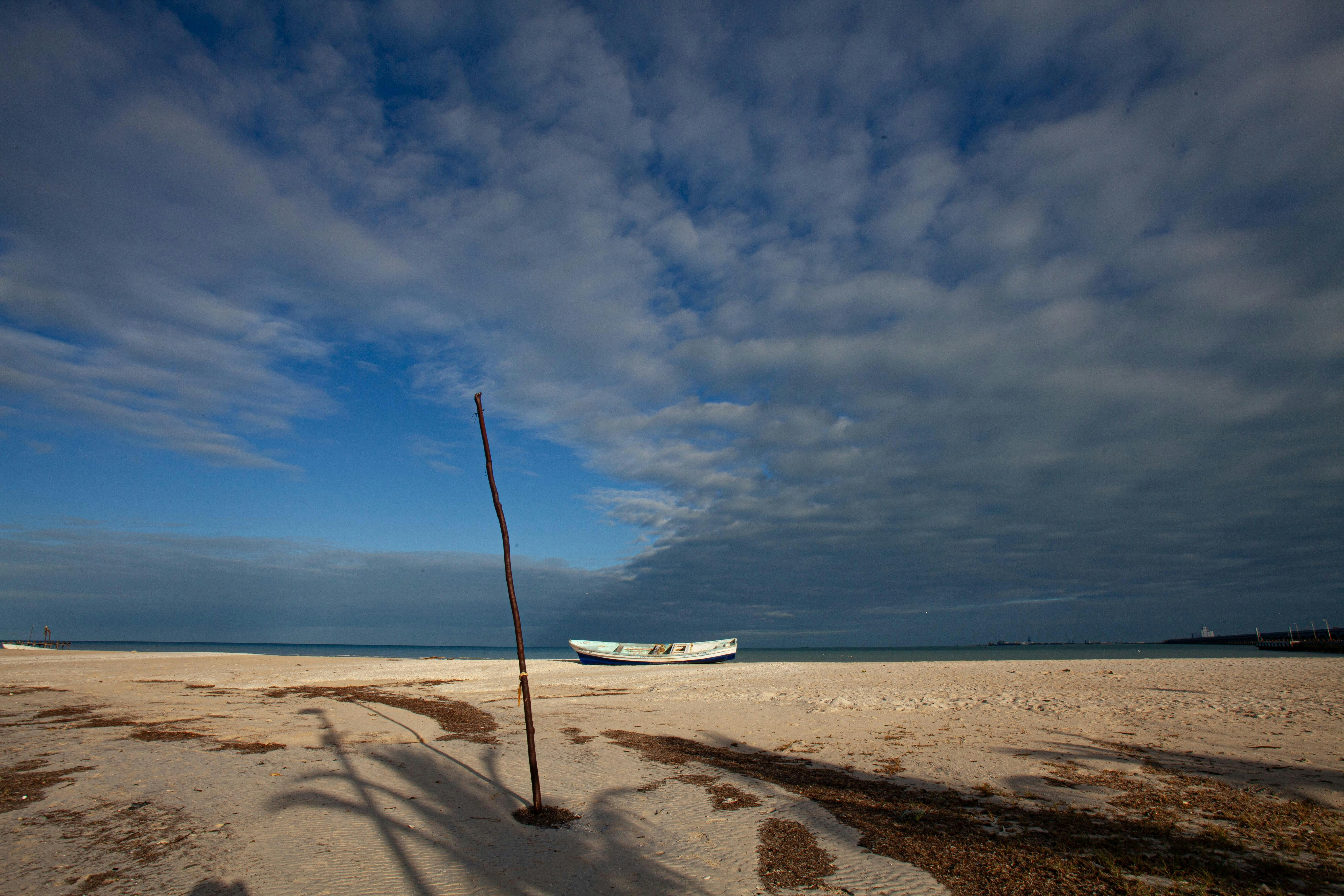 a boat sitting on top of a sandy beach