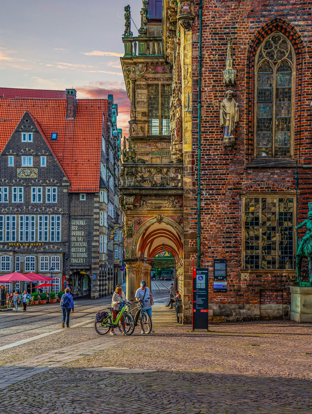 a group of people walking down a street next to tall buildings