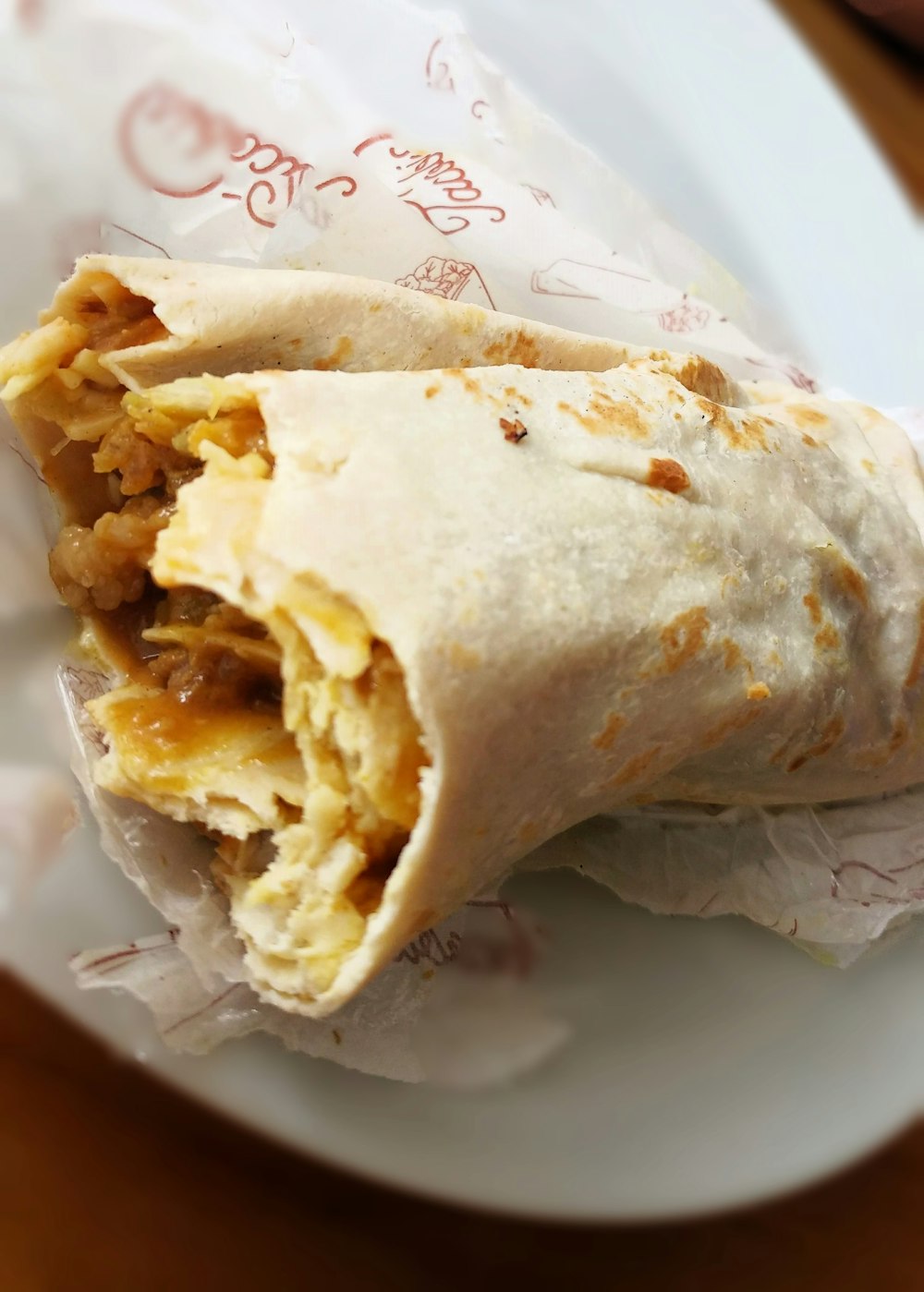 a burrito wrapped in a wrapper on a plate