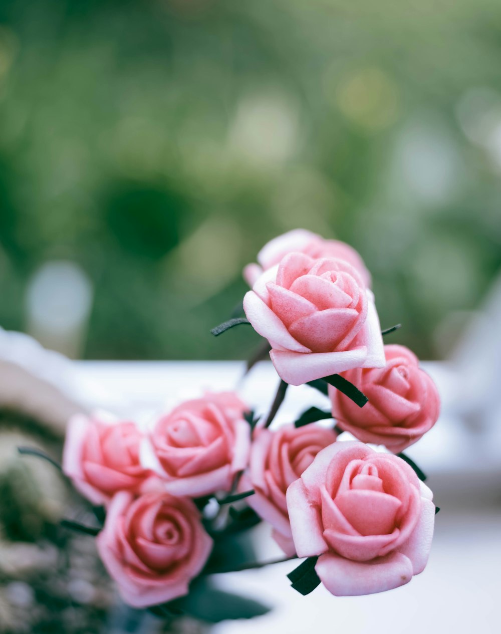 a bouquet of pink roses sitting on top of a table