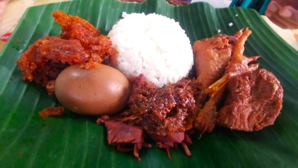 a close up of a plate of food on a banana leaf