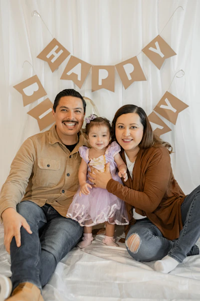 a man and a woman pose for a picture with a baby