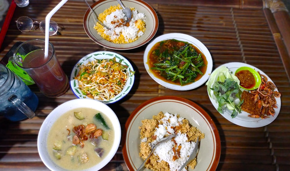 ein Tisch mit Tellern mit Essen und Schüsseln mit Suppe