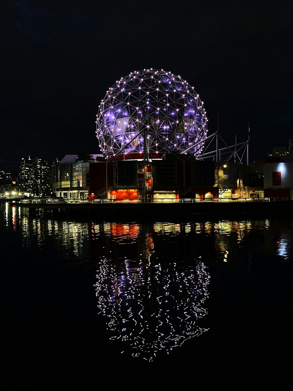 a night view of a city with lights reflecting in the water