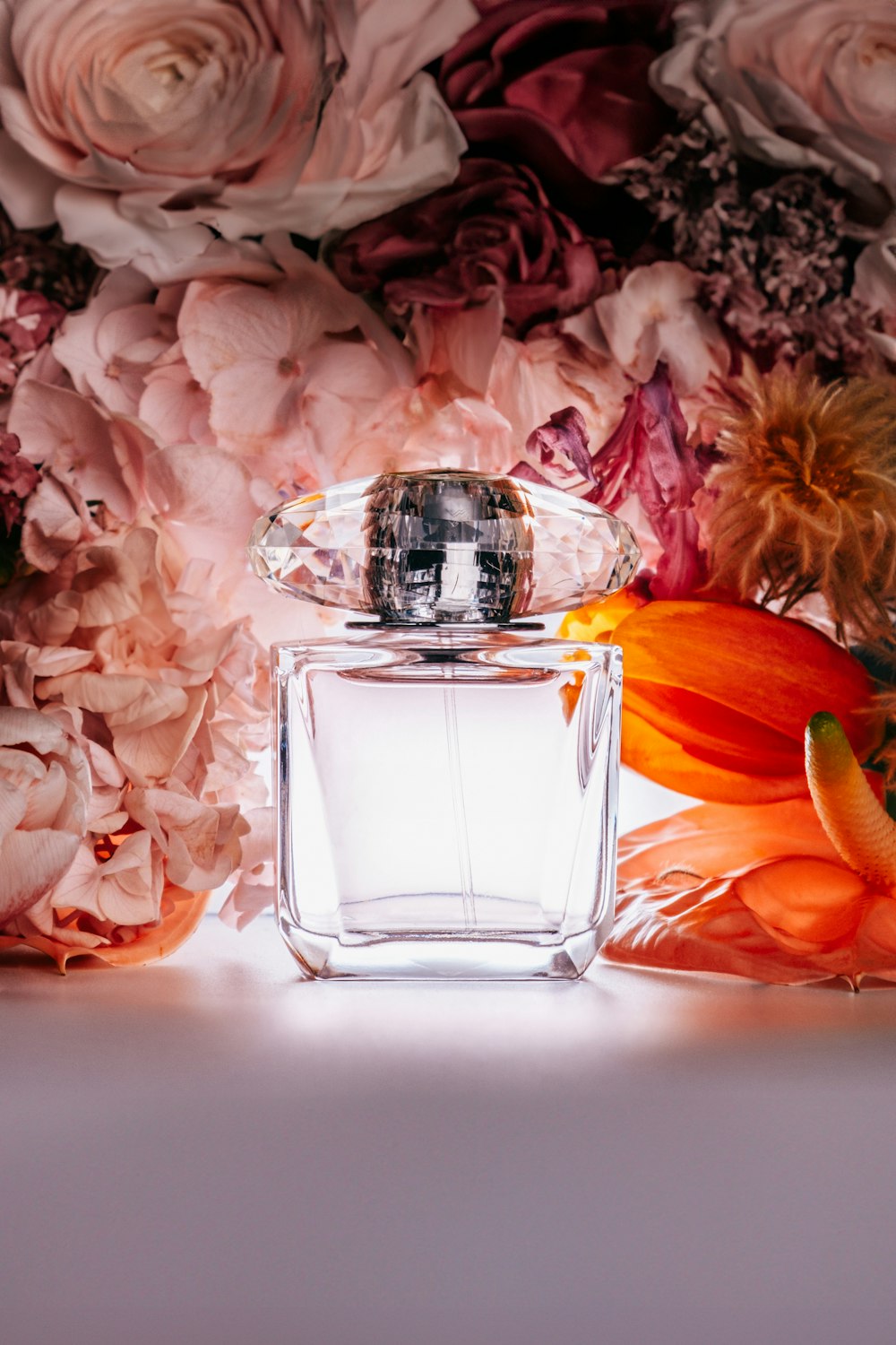 a bottle of perfume sitting next to a bunch of flowers